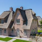 House with thatched roof and brick facade