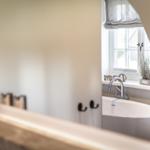Bathroom with bathtub, window, and plant on the sill.