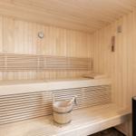 Sauna with wooden bench, thermometer, and stone heater