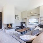 Living room with fireplace, sofa, and TV mounted on the wall.
