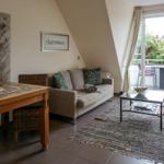 Living room with sofa, table, and terrace. Glass door opens to outdoor terrace.