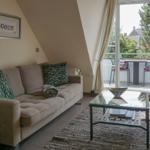 Living room with sofa, coffee table, and balcony view.