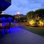 Terrasse mit Tisch, Stühlen und Beleuchtung im Garten bei Dämmerung.