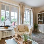 Wohnzimmer mit großem Fenster, Segelbootmodell und Fernseher.