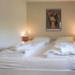 Bedroom with bed, nightstands, and wall art
