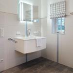 Bathroom with sink, mirror, and window.