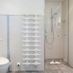 Bathroom with shower, toilet, and modern radiator.