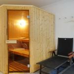 Sauna with wooden cladding and two chairs outside