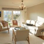 Living room with sofa, chairs, and window to outdoor terrace.