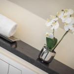 White towel roll and orchid on dark countertop edge