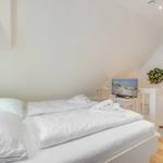 Bedroom with double bed, TV, and mirror on the wall.