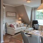 Living and dining area with sofa, table and chairs. Window with view of outside.