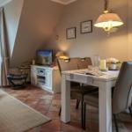 Dining area with table and chairs, TV, and seating area in attic space.