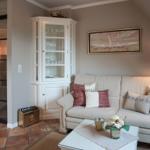 Living room with sofa, coffee table, and wine cabinet under sloped ceiling.