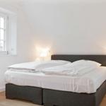 Bedroom with double bed, window, and bedside tables with lamps.