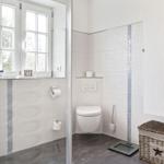 Bathroom with toilet, window, and storage box.