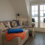 Living room with sofa, table, and window to terrace.