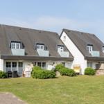 House with dormers and garden. Outdoor shower and lounge chairs.