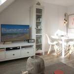 Living and dining area with TV, table, chairs, and cabinet.