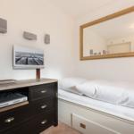 Schlafzimmer mit Bett, Spiegeln und Fernseher