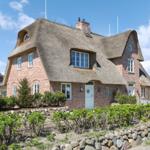 Haus mit Strohdach, Backsteinfassade und Garten