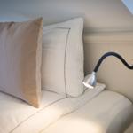Bettkopf mit Kissen und Wandlampe unter Dachschrägen