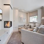 Wohnzimmer mit Kamin, Sofa und Fernseher an der Wand