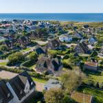 Dorf mit Häusern und Meer im Hintergrund
