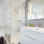 Bathroom with shower, sink, and window.