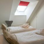 Bedroom with sloped ceiling, skylight, and bed with towels.