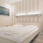 Schlafzimmer mit Bett, Wandbild und Streifenwand