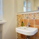 Waschbecken mit Steinwand, Spiegel und Fenster