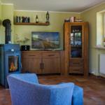 Wohnzimmer mit Kamin, Fernseher und Holzmöbeln.