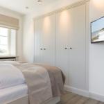 Schlafzimmer mit Bett, Kleiderschrank und Wandbild