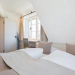 Schlafzimmer mit Bett, Schreibtisch und Fenster