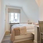 Schlafzimmer mit Bett, Fenster und Schreibtisch