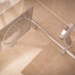 Duschsystem mit Handbrause und Wandbrause auf Fliesenboden