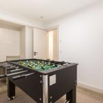 Fussballtisch mit Dartboard an der Wand