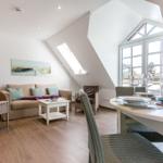 Living and dining area with sofa, table, and windows