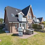 House with terrace, grill, and garden. Modern design with wooden and stone cladding.