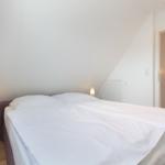 Schlafzimmer mit Doppelbett und zwei Nachttischen mit Lampen.