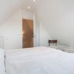 Schlafzimmer mit Doppelbett, Schreibtisch und Fernseher