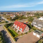 Haus mit rotem Dach, Garten und Blick aufs Meer.