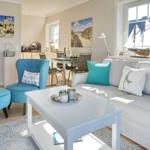 Wohnzimmer mit Sofa, blauer Sessel und Essbereich