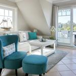 Ein Wohnzimmer mit blauer Sitzgelegenheit, Sofa und Terrasse.