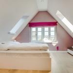 Schlafzimmer mit Dachschrägen, Fenster und Bett