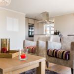 Wohnzimmer mit Sitzgruppe, Küchenbereich und Holztisch