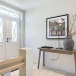 Entrance area with table, lamp, and picture on the wall.