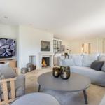 Living room with fireplace, sofa, and TV. Round coffee table and decorative candles.