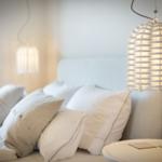 Bedroom with bed, pillows, and hanging lamps.